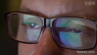 <strong>特写</strong>男子的<strong>眼睛</strong>在笔记本电脑上工作的眼镜在夜间宏年轻男子戴眼镜上网